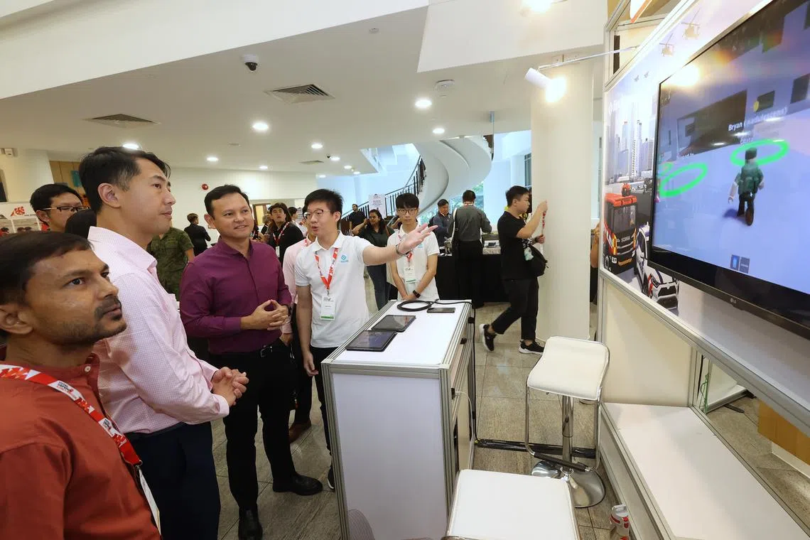 Senior Minister of State for Defence Zaqy Mohamad (third from left) viewing the Total Defence exhibition on April 25.