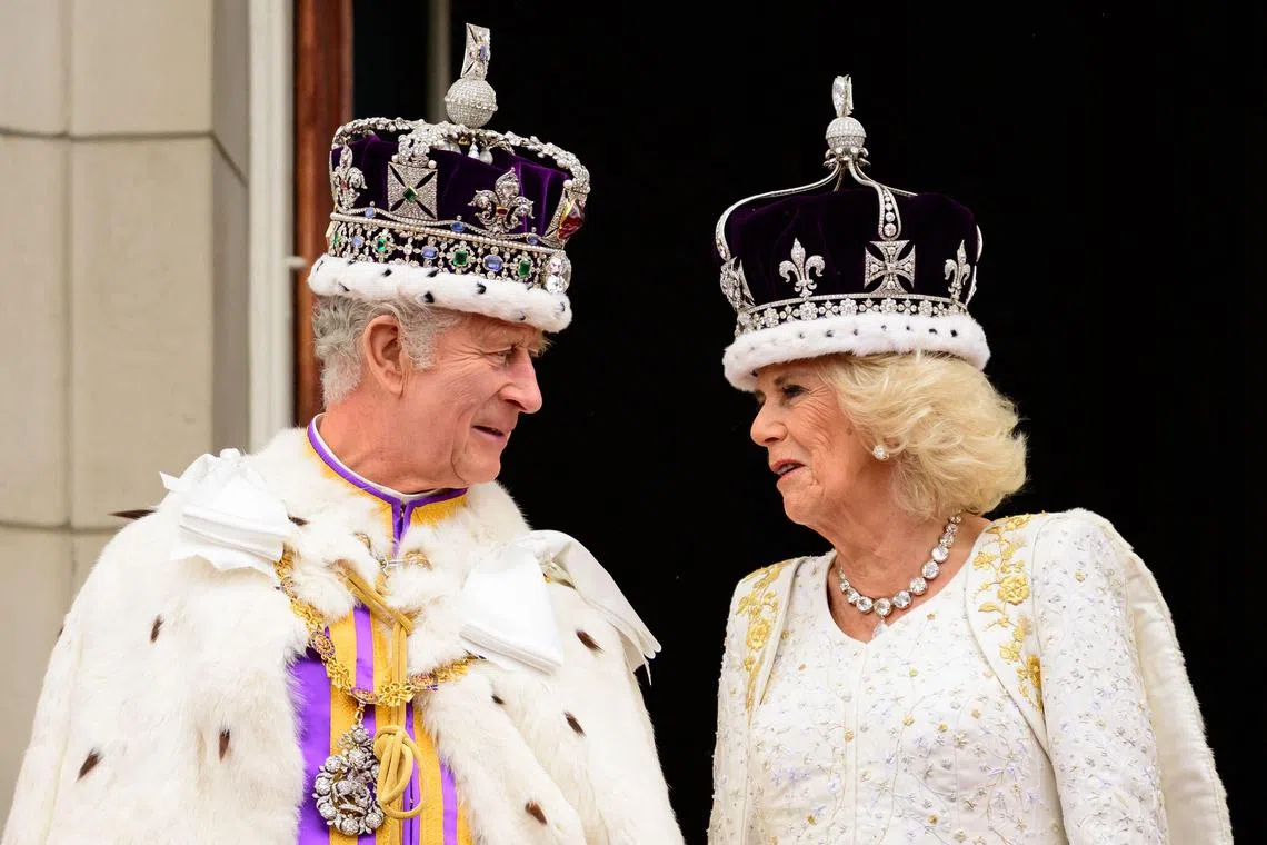 Britain's King Charles III (L) looking at Queen Camilla as they stand on the Buckingham Palace balcony, in London, following their coronations on May 6, 2023.