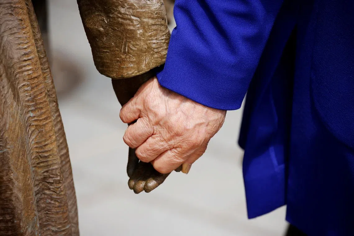 FILE PHOTO: Former South Korean \"comfort woman\" Lee Yong-soo holds the hand of a statue symbolising \"comfort women\" at the Seoul Comfort Women Memorial in Seoul, South Korea, June 29, 2021.   REUTERS/Kim Hong-Ji/File Photo