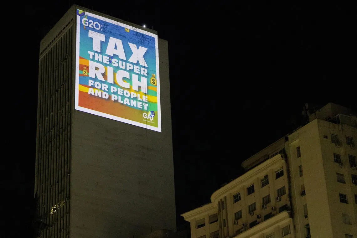 Climate activists from the Glasgow Actions team project a message with an appeal for the taxation of the super-rich on a building during the G20 Summit in Rio de Janeiro, Brazil November 18, 2024. REUTERS/Tuane Fernandes