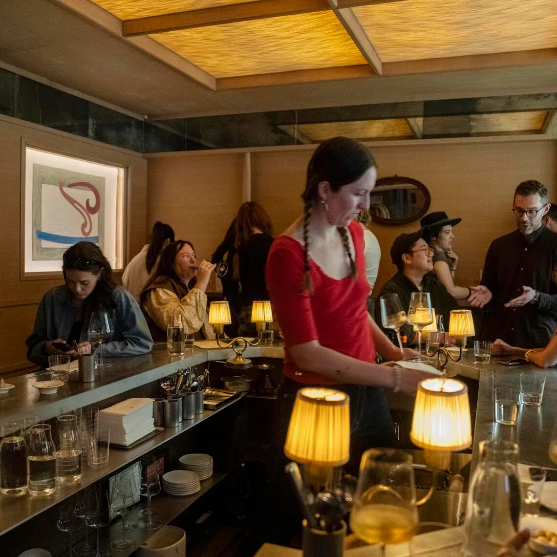 Mr Chase Sinzer, a partner at the wine bar Stars, talking to customers at right at the establishment in Manhattan on March 11. 