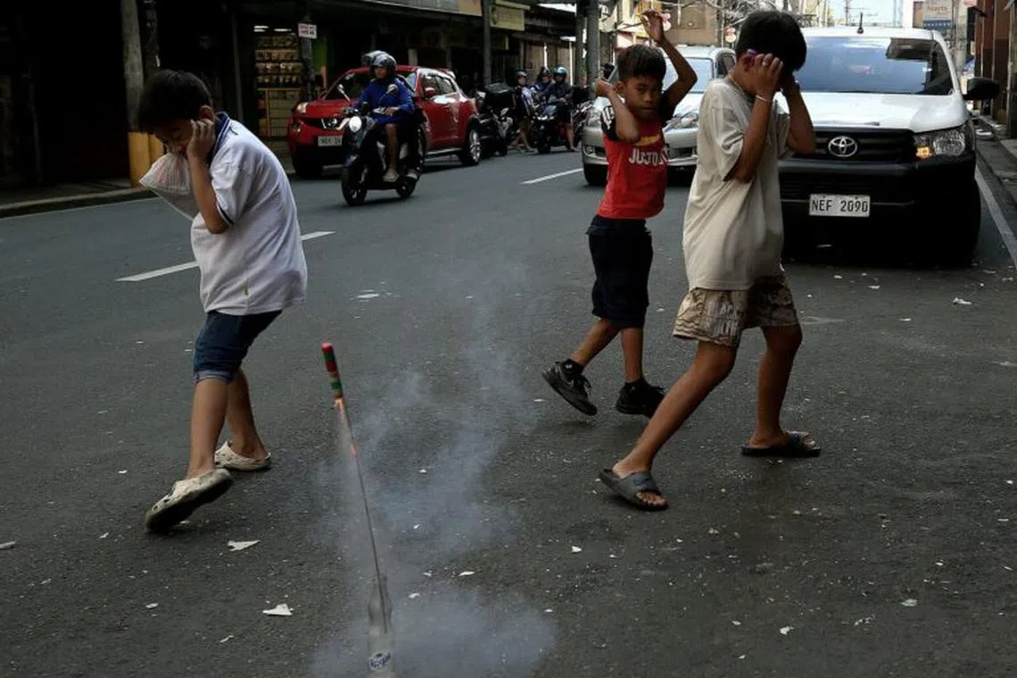 Children light firecrackers at Juan Luna Street in Manila on New Year’s Eve 2023.

 