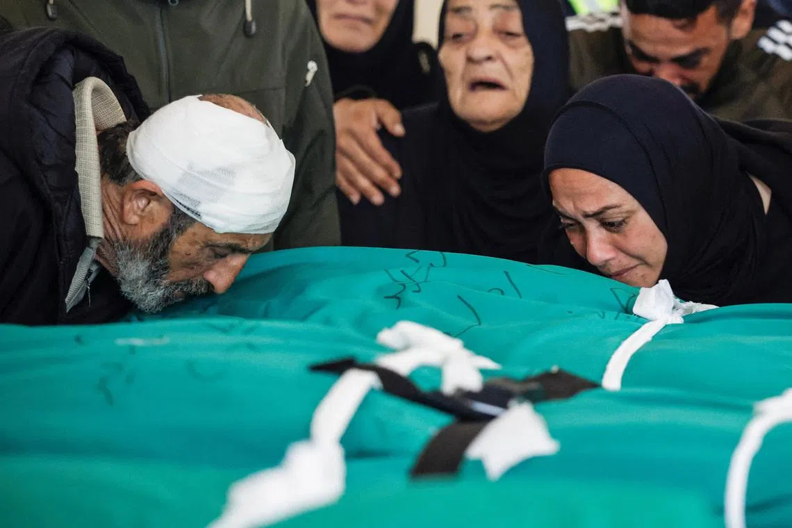 Mr Nasser Hussein Saeed, 64, kisses the body of his daughter Fatima, 39, during the funeral service of four members of his family, including his 1.5-year-old granddaughter Taleen, killed in an Israeli strike on Lebanon.