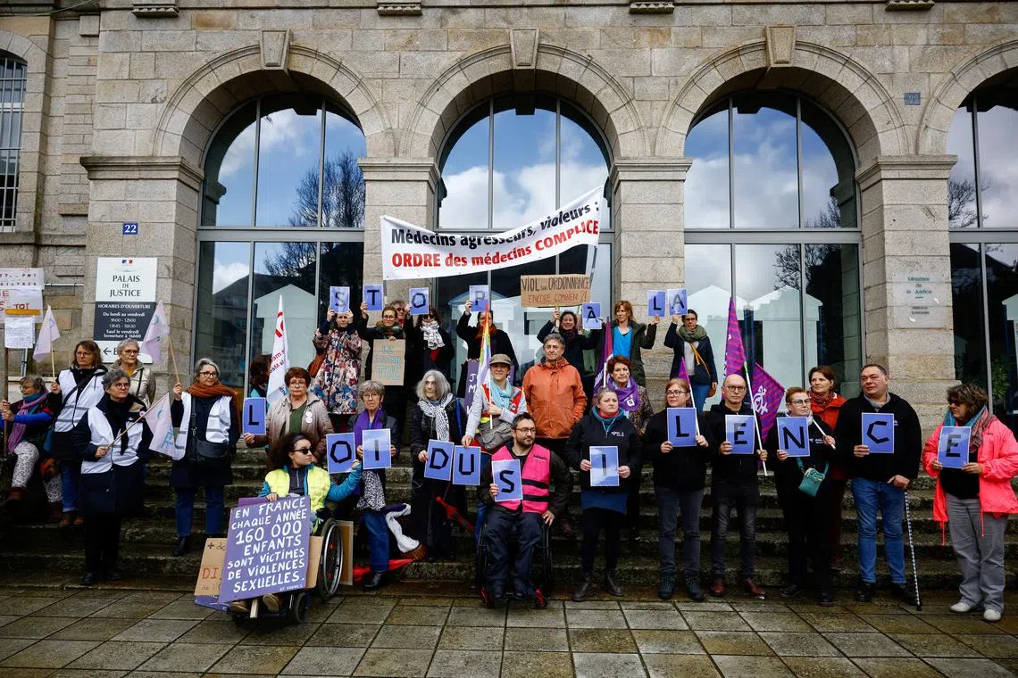 People demonstrating in front of the courthouse on the opening day of Joel Le Scouarnec's trial.