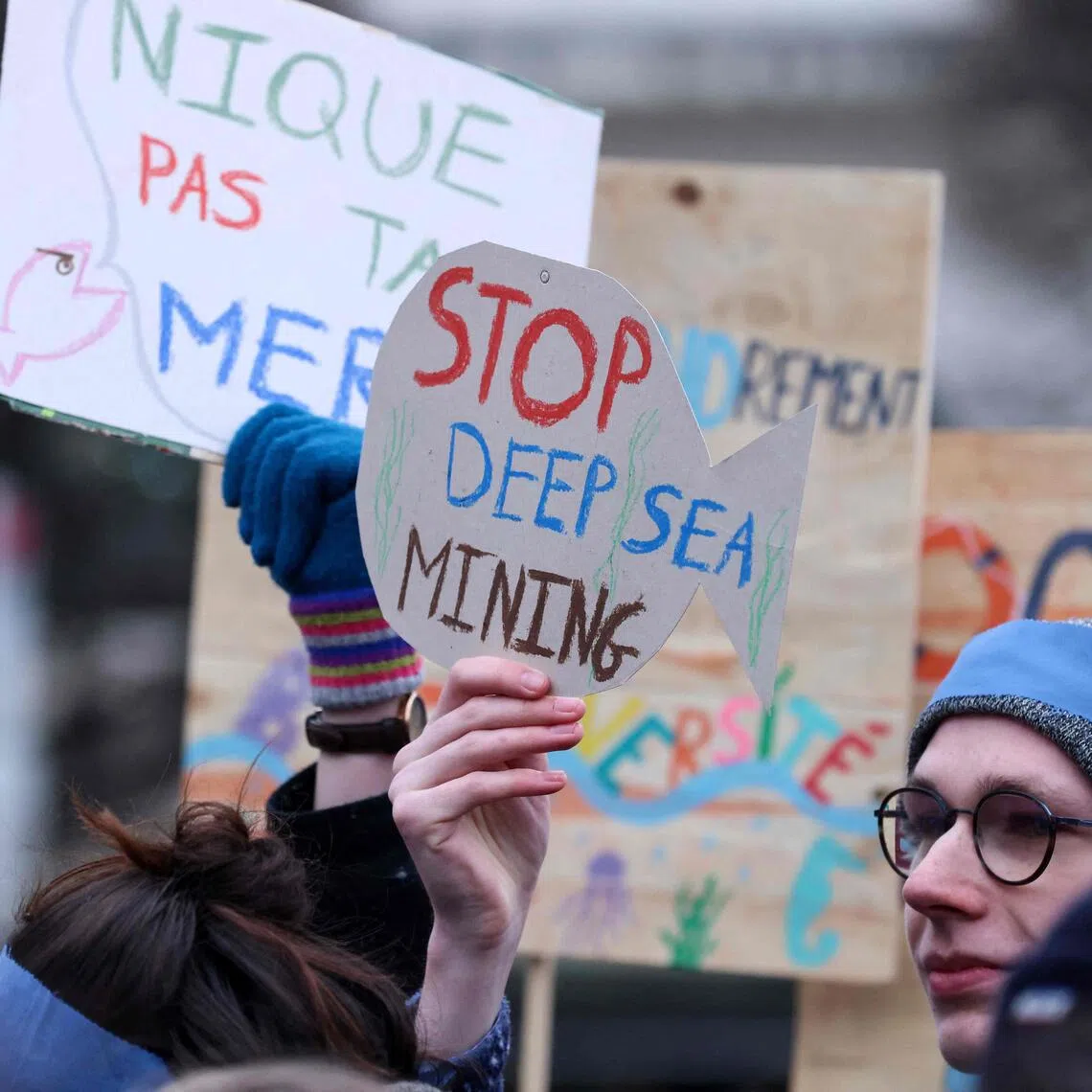 Activists take part at a "Look Down action" rally to stop deep sea mining outside the European Parliament, in Brussels, in 2023.