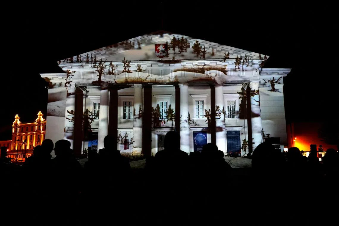 People watch light illumination during Lithuanian capital's 700th anniversary celebration with the festival of lights in Vilnius, Lithuania Jan 25, 2023. 