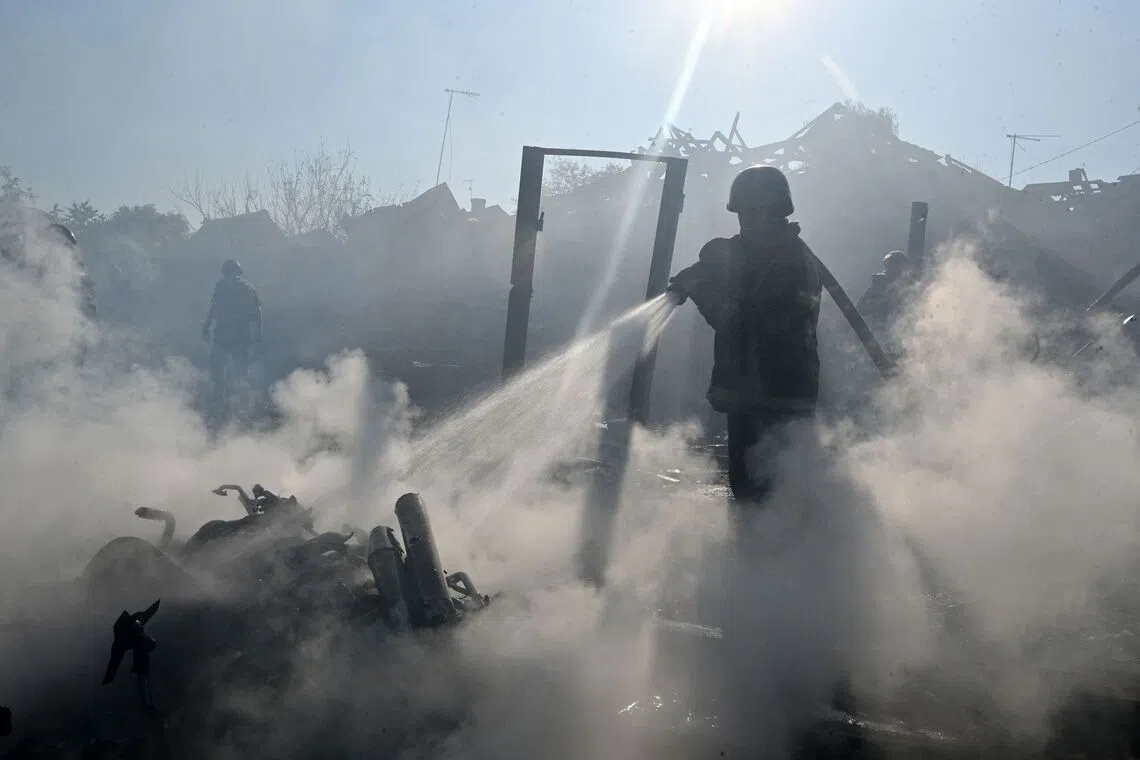 TOPSHOT - A firefighter extinguishes a fire in private houses following a Russian guided aerial bomb attack that killed one person, amid the Russian invasion of Ukraine, in Kharkiv on October 11, 2026. (Photo by SERGEY BOBOK / AFP)