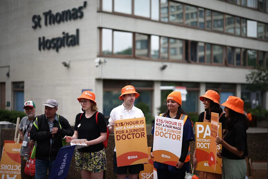 Junior doctors protesting during a strike for better pay outside St Thomas' Hospital in central London, on June 27.