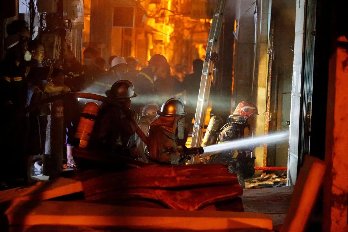 Firefighters battle a blaze engulfing an apartment block in Hanoi on Sept 13, 2023.