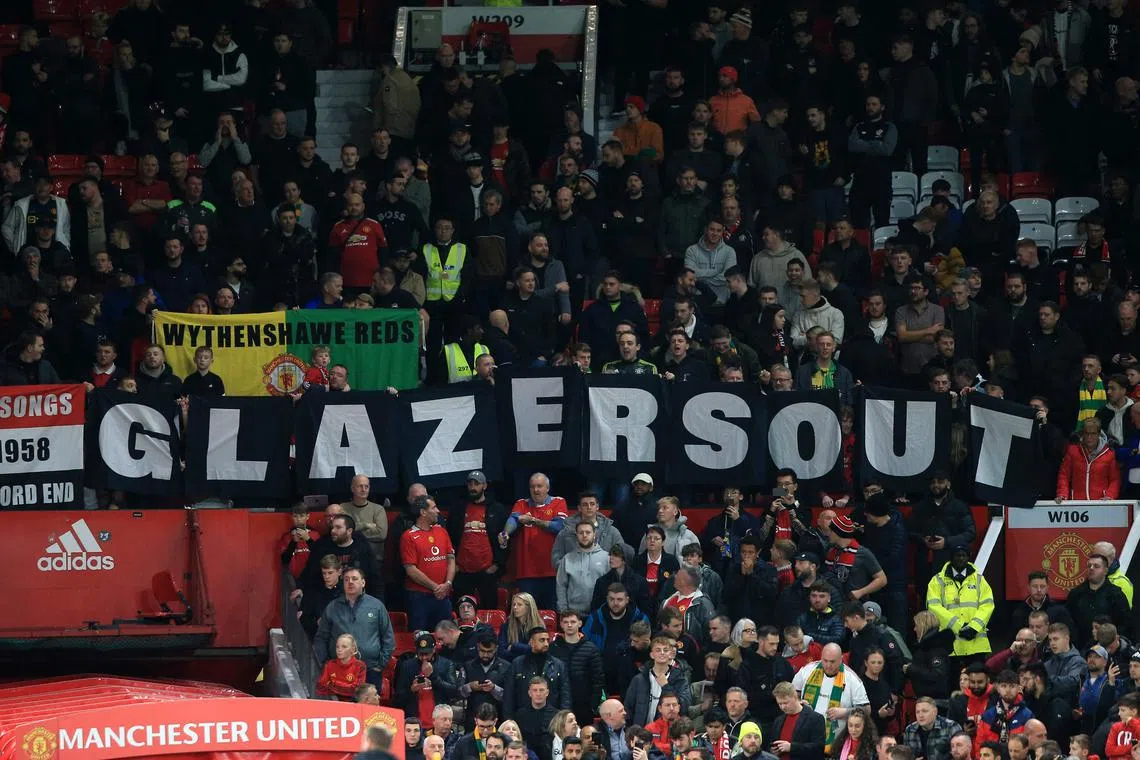 Manchester United fans hold a banner reading "Glazers Out" at a football match between Manchester United and Aston Villa on Nov 10, 2022.