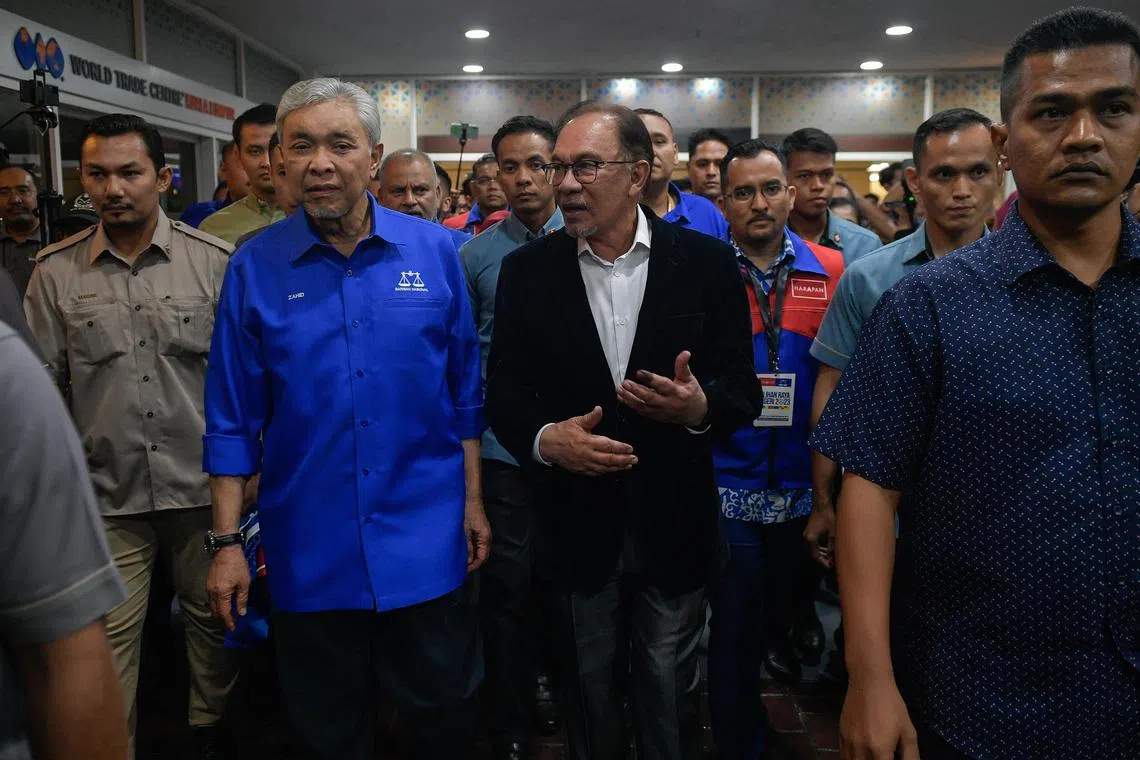 Pakatan Harapan chairman Anwar Ibrahim accompanied by Barisan Nasional chairman Zahid Hamidi in Umno headquarters at the World Trade Centre on Aug 12.