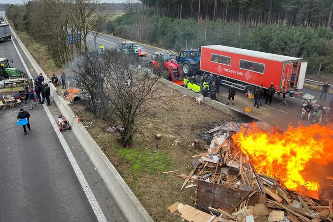 FILE PHOTO: Farmers use their tractors to block a highway near the border with the Netherlands as they protest over price pressures, taxes and green regulation, grievances shared by farmers across Europe, in Arendonk, Belgium February 2, 2024. REUTERS/Christian Levaux