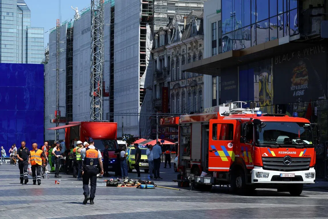 A member of the police walking near a fire truck, following a fire at Oxy Brussels building in Brussels, Belgium, on July 14.