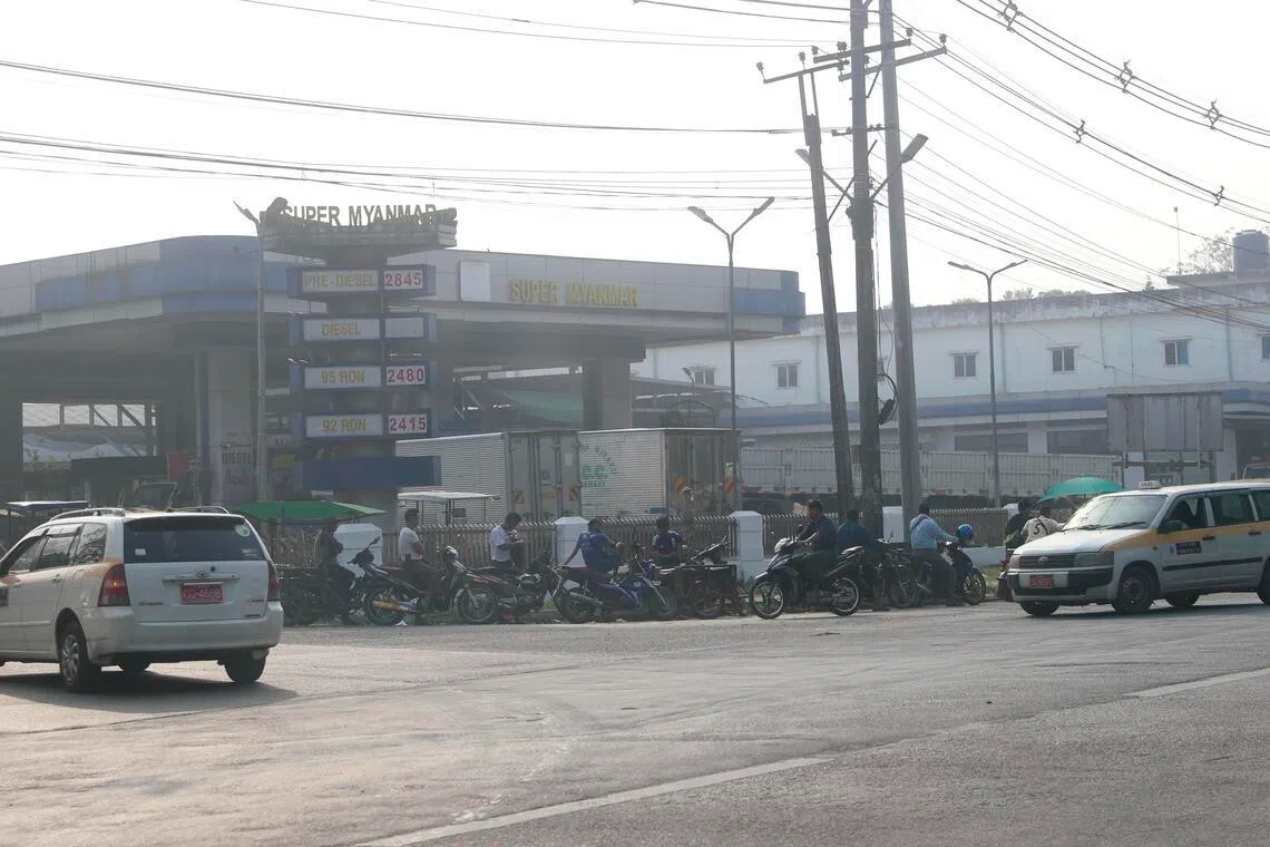 Motorbikes and cars queue at a petrol station in Yangon.