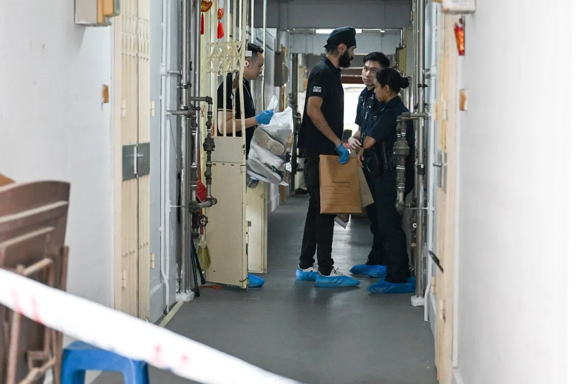 Police officers taking evidence from a flat on the 19th floor of Block 51 Chin Swee Road.