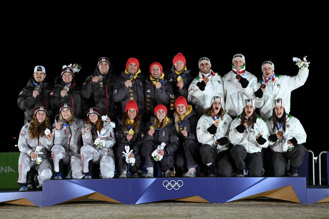 Milano Cortina 2026 Olympics - Luge - Team Relay Victory Ceremony - Cortina Sliding Centre, Cortina d'Ampezzo, Italy - February 12, 2026. Gold medallists Julia Taubitz of Germany, Tobias Wendl of Germany, Tobias Arlt of Germany, Max Langenhan of Germany, Dajana Eitberger of Germany and Magdalena Matschina of Germany celebrate on the podium after winning the Team Relay with silver medallists Lisa Schulte of Austria, Thomas Steu of Austria, Wolfgang Kindl of Austria, Jonas Mueller of Austria, Selina Egle of Austria and Lara Michaela Kipp of Austria and bronze medallists Verena Hofer of Italy, Emanuel Rieder of Italy, Simon Kainzwaldner of Italy, Dominik Fischnaller of Italy, Andrea Voetter of Italy and Marion Oberhofer of Italy REUTERS/Annegret Hilse