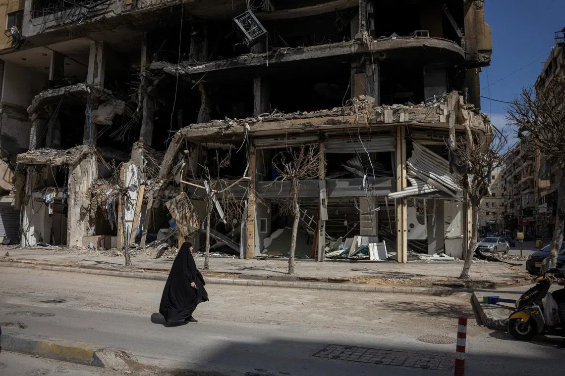 A woman walking past damaged buildings amid a 10-day ceasefire between Lebanon and Israel, in the southern suburbs of Beirut, Lebanon, on April 20, 2026. 