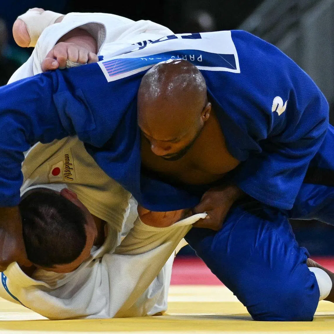 France's Teddy Riner (blue) and Japan's Tatsuru Saito competing in the judo mixed team gold medal bout on Aug 3.
