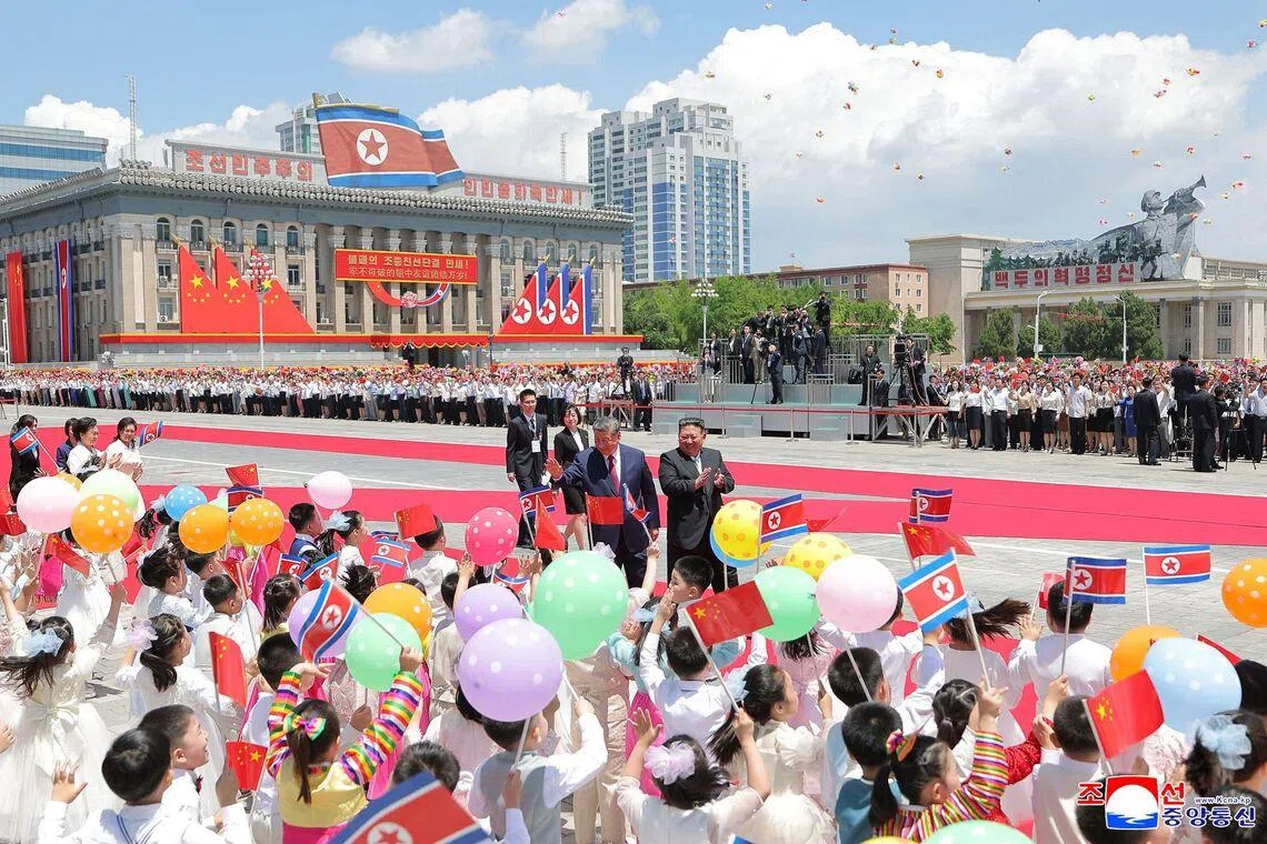 Chinese President Xi Jinping (left) and North Korean leader Kim Jong Un at a welcome ceremony for Xi in Pyongyang on June 8.