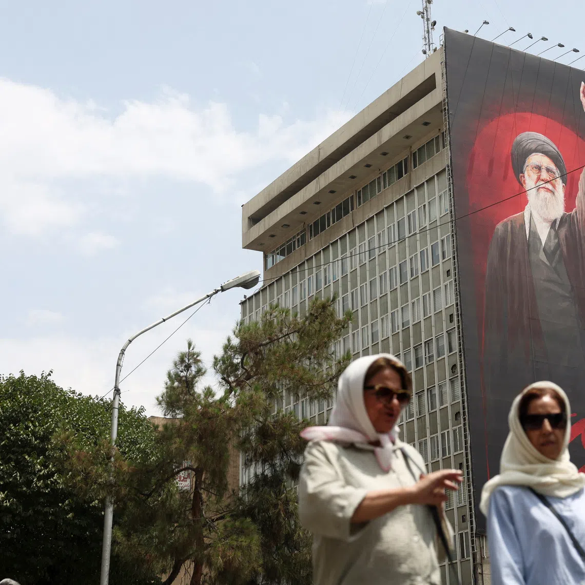 People walk near a billboard depicting Iran's late Supreme Leader Ayatollah Ali Khamenei, on a street in Tehran, Iran, August 3, 2026. Majid Asgaripour/WANA (West Asia News Agency) via REUTERS