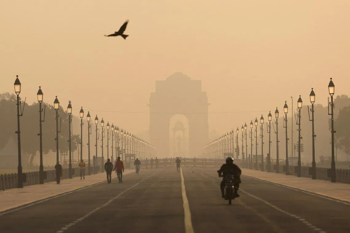 FILE PHOTO: People walk on Kartavyapath near India Gate on a hazy morning in New Delhi, India, November 1, 2024.REUTERS/Anushree Fadnavis/File Photo