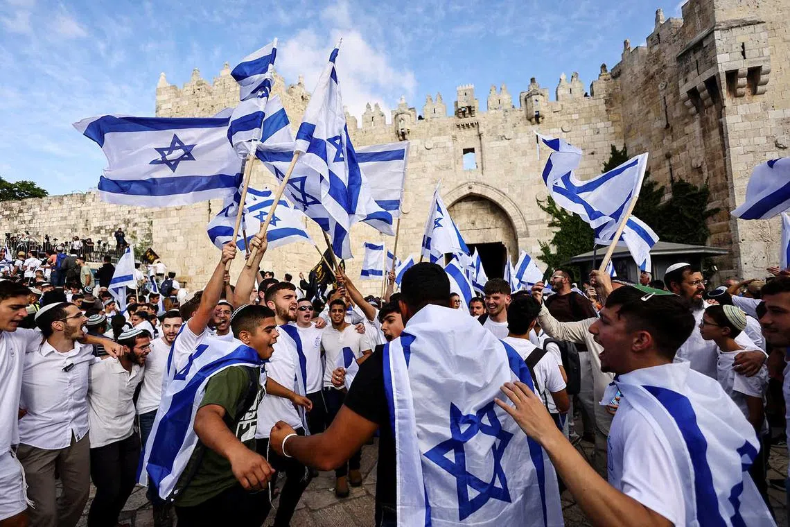 Israelis sing and dance with flags by Damascus gate to Jerusalem's Old city as they mark Jerusalem Day, in Jerusalem May 18.