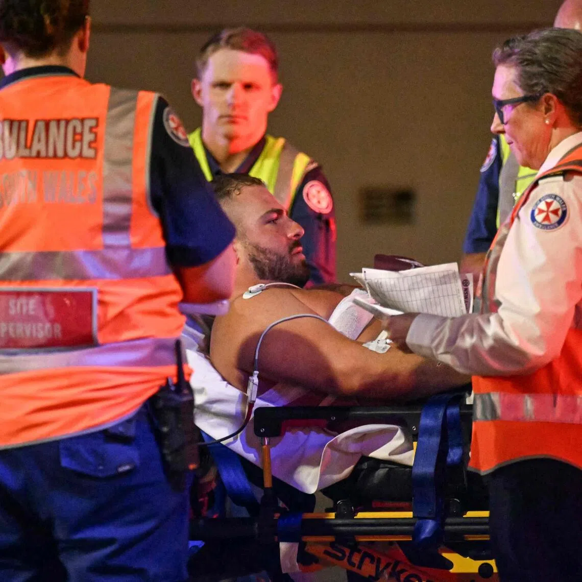 Health workers move a man on a stretcher to an ambulance after a shooting incident at Bondi Beach in Sydney on Dec 14, 2025.  