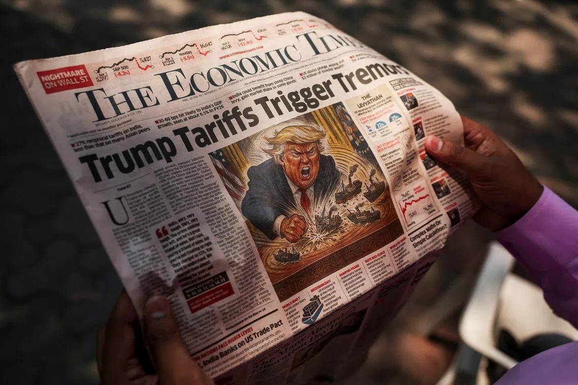 FILE PHOTO: A man reads a newspaper outside the Bombay Stock Exchange (BSE) after Trump's tariff plan announcement, in Mumbai, India, April 4, 2025. REUTERS/Francis Mascarenhas/File Photo