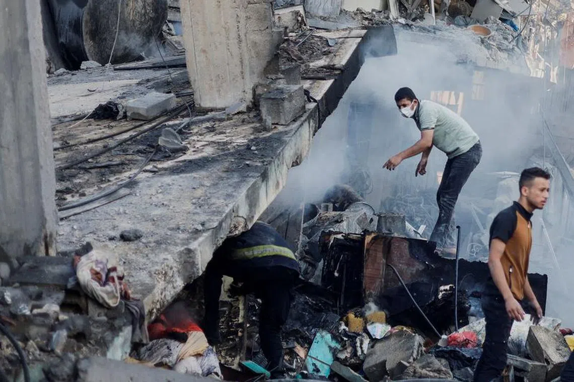 Palestinians search for casualties under the rubble in the aftermath of Israeli strikes, amid the ongoing conflict between Israel and the Palestinian Islamist group Hamas, in Khan Younis in the southern Gaza Strip, October 14, 2023. REUTERS/Mohammed Salem