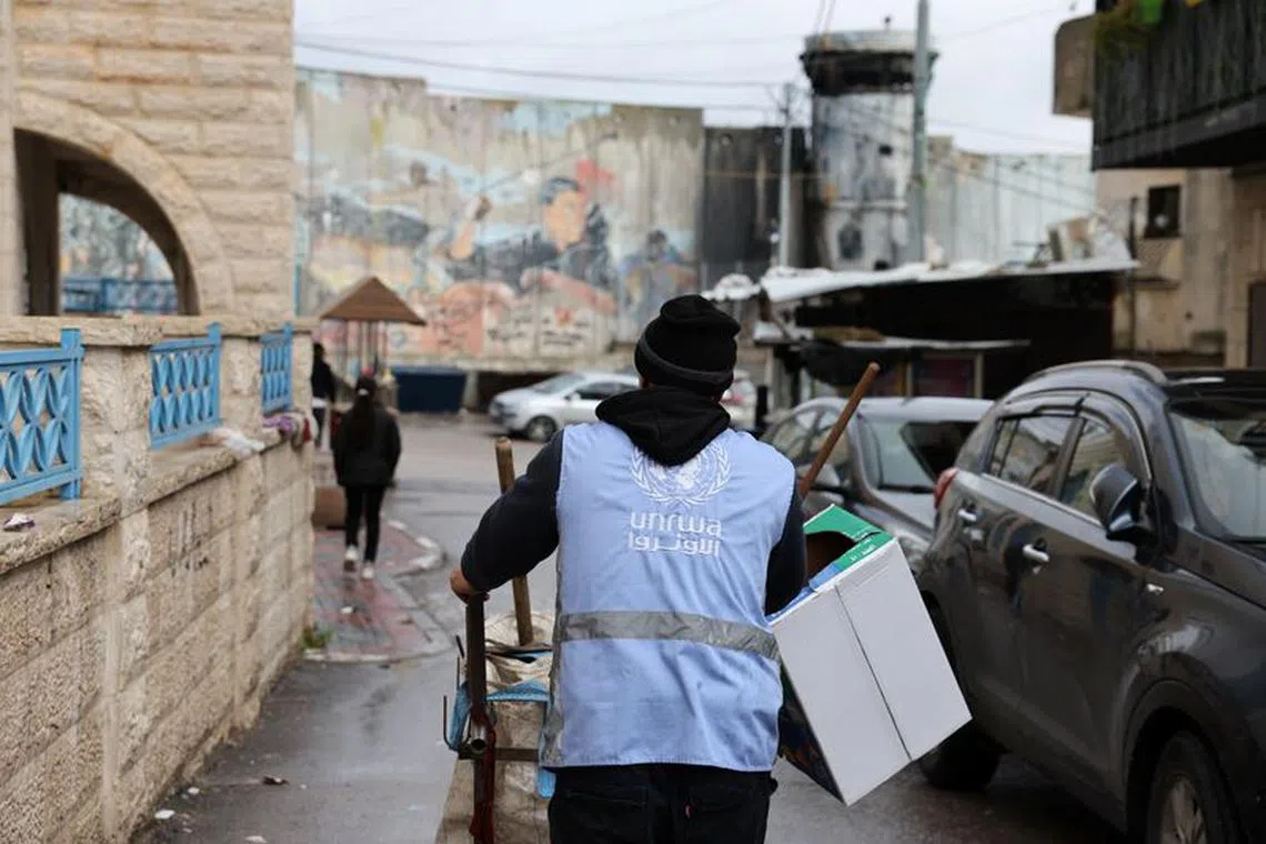 FILE PHOTO: A UNRWA worker pushes a cart in the Aida refugee camp in Bethlehem in the Israeli-occupied West Bank, February 5, 2024. REUTERS/Mussa Qawasma/File Photo