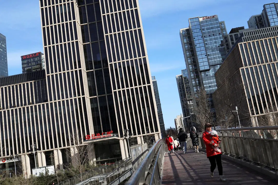 People walk on a pedestrian bridge at the central business district (CBD) during morning rush hour, ahead of the opening of the National People's Congress (NPC), in Beijing, China, February 29, 2024. REUTERS/Florence Lo