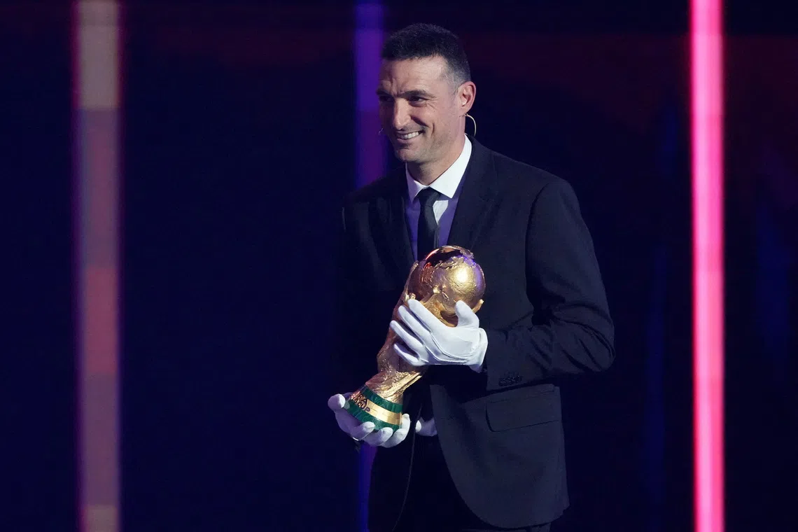 Soccer Football - FIFA World Cup 2026 - FIFA World Cup 2026 Draw - John F. Kennedy Center for the Performing Arts, Washington, D.C., U.S. - December 5, 2025 Argentina coach Lionel Scaloni brings the World Cup trophy onto stage during the FIFA World Cup 2026 draw Pool via REUTERS/Stephanie Scarbrough