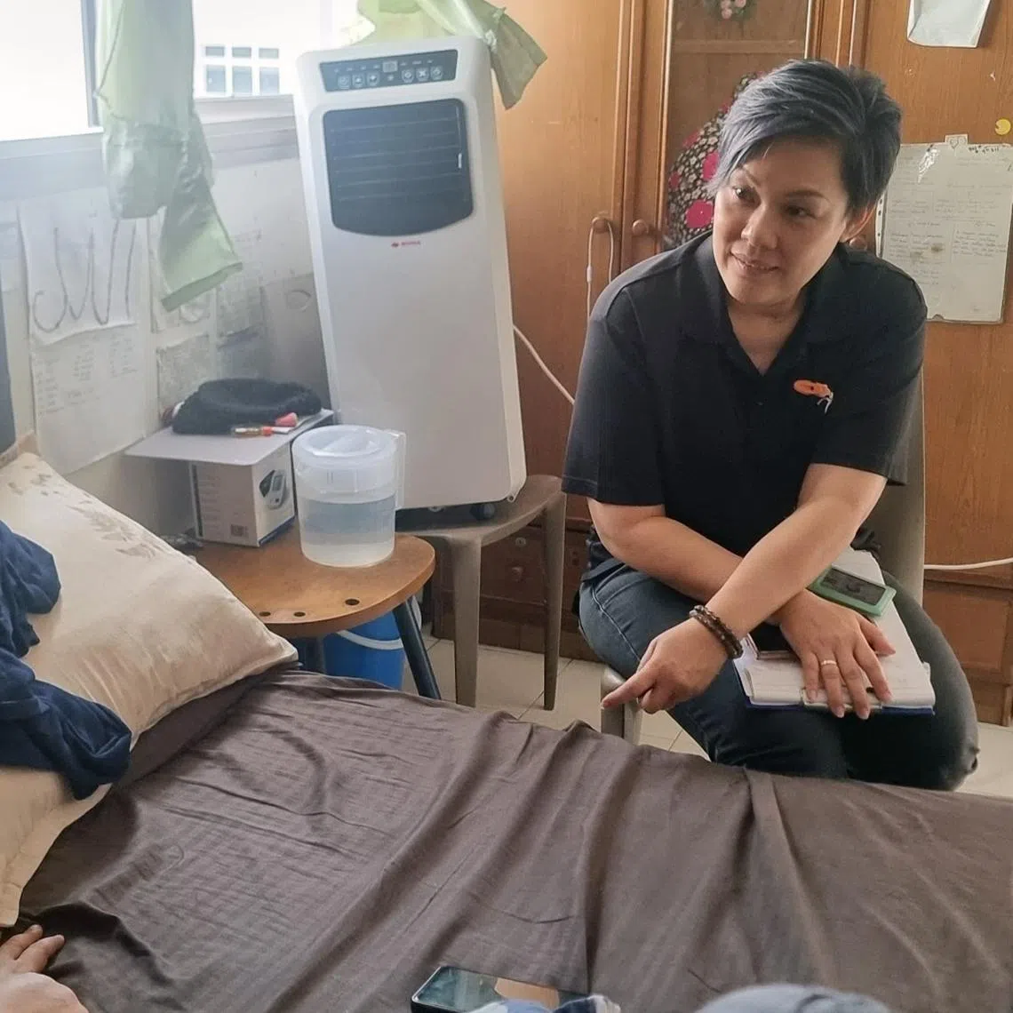msf family coach speaking with low income family in singapore in rental apartment and discuss possible social and financial assistance