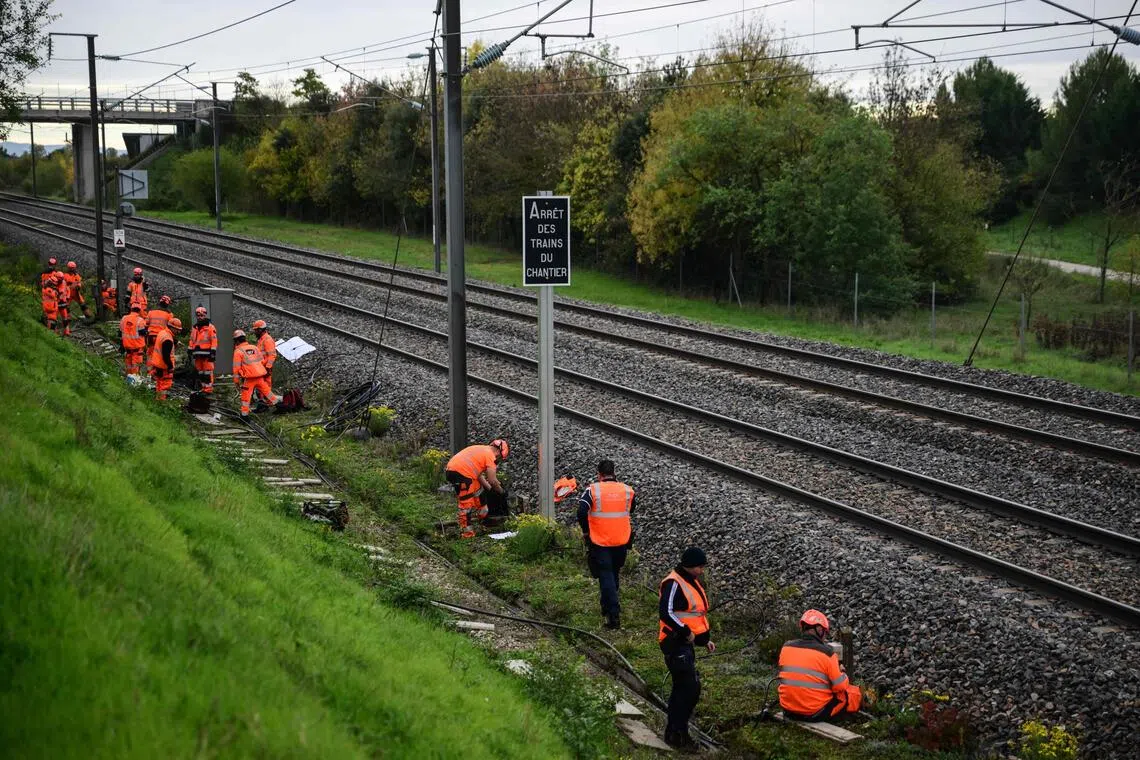 Workmen dealing with charred cables and equipment along a section of railway line affected by arson, south of Valence's TGV railway station, in the south-east of the country, on Oct 27.