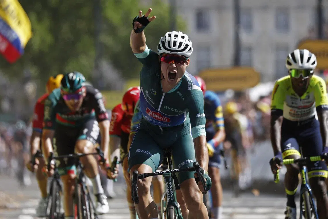 Alpecin–Deceuninck's Jasper Philipsen celebrating as he crosses the finish line to win stage seven of the Tour de France.