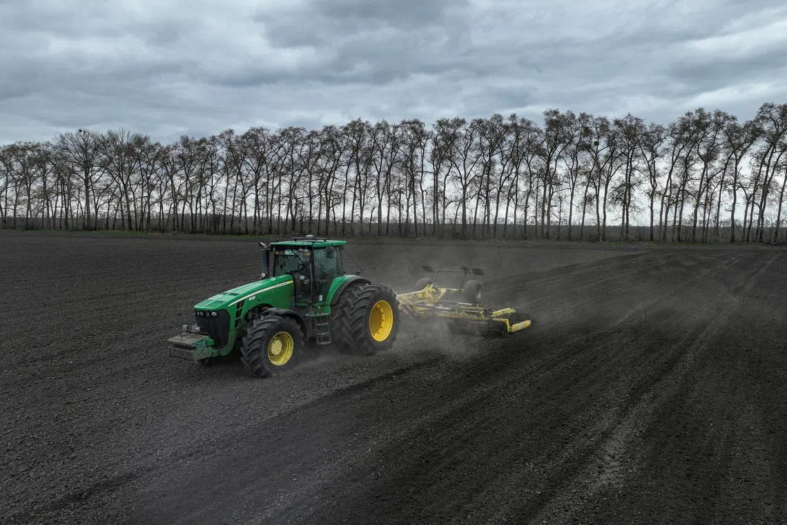 An agriculture worker drives a tractor as he prepares soil for sowing buckwheat in the village of Malopolovetske, amid Russia's attack on Ukraine, in the Kyiv region, Ukraine, April 6, 2026. REUTERS/Valentyn Ogirenko