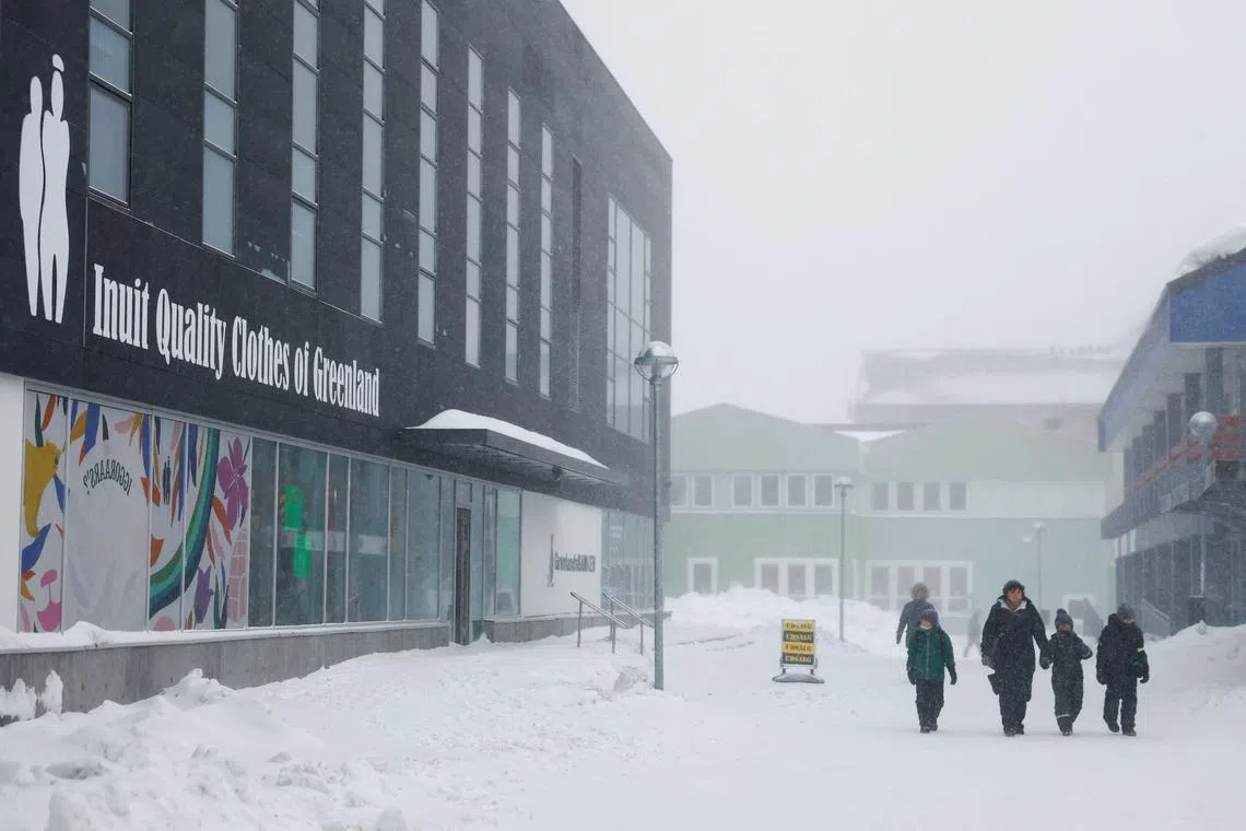 FILE PHOTO: People walk near a Inuit clothing shop in Nuuk, Greenland, February 6, 2025. REUTERS/Sarah Meyssonnier/File Photo