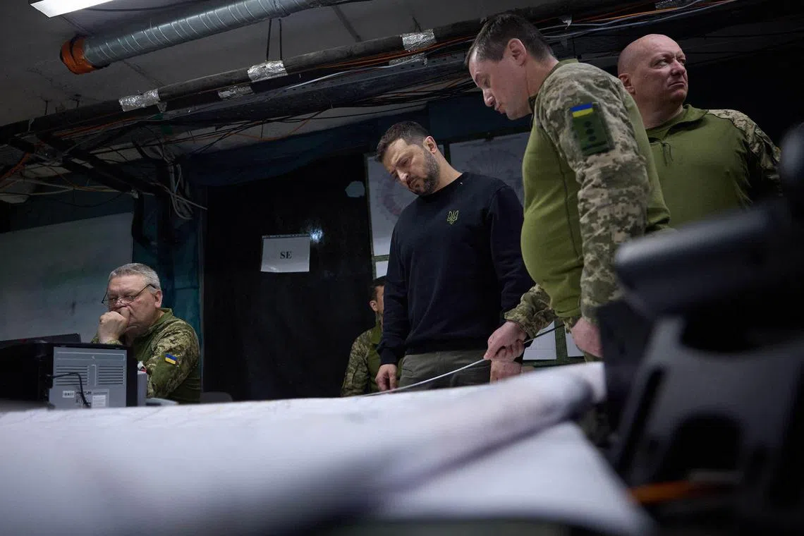 Ukrainian President Volodymyr Zelensky (centre) visits front-line positions in Ukraine's Donetsk region.