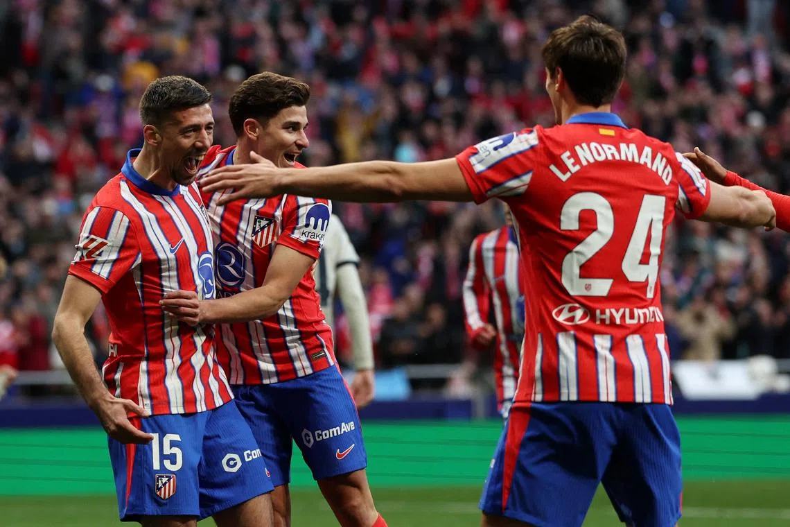 Soccer Football - LaLiga - Atletico Madrid v Osasuna - Metropolitano, Madrid, Spain - January 12, 2025 Atletico Madrid's Julian Alvarez celebrates scoring their first goal with Clement Lenglet and Robin Le Normand REUTERS/Violeta Santos Moura