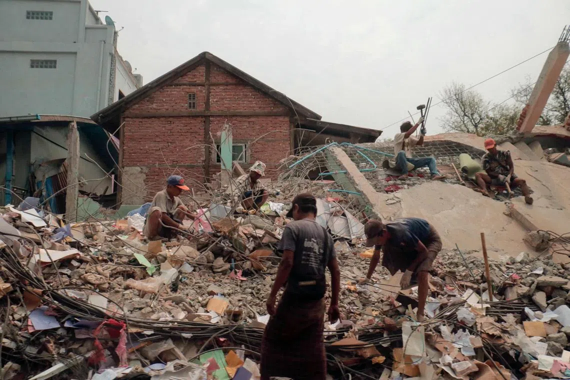 People sort through the rubble of a collapsed building in Mandalay on April 5.