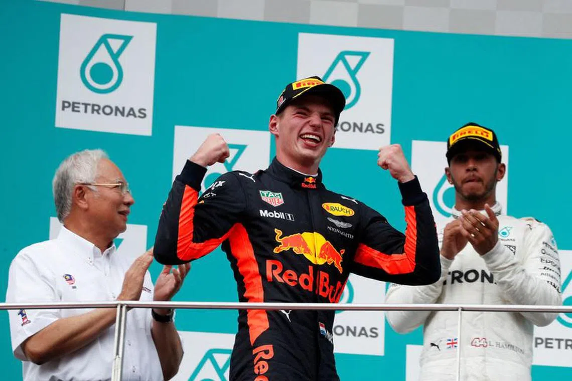 FILE PHOTO: Formula One F1 - Malaysia Grand Prix - Sepang, Malaysia - October 1, 2017. Redbull's Max Verstappen celebrates winning the race between Malaysian Prime Minister Najib Razak and Mercedes’ Lewis Hamilton. REUTERS/Edgar Su/File Photo