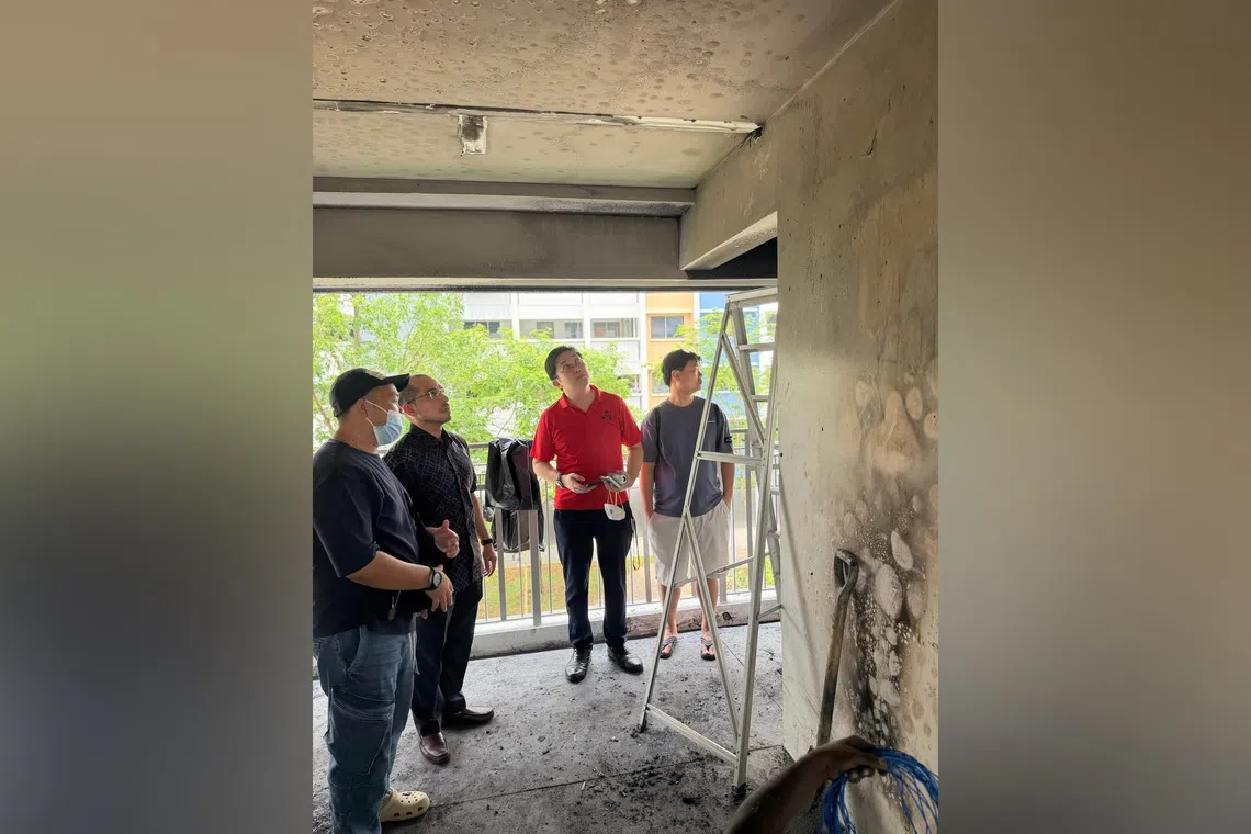Nee Soon GRC MP Syed Harun Alhabsyi (2nd from left) and grassroots leaders looking at the damage caused by the PMA fire on the third-floor landing of Block 438 Yishun Ave 11.