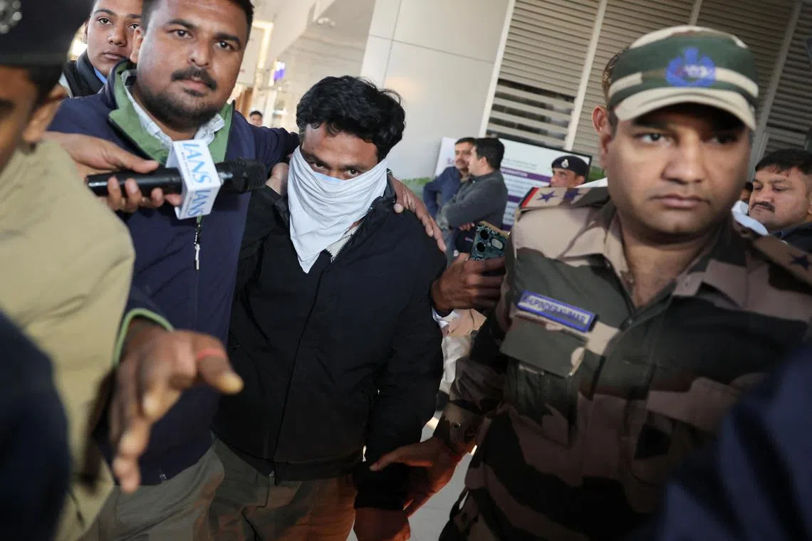 Security personnel escort an Indian immigrant deported from the USas they leave the airport in Ahmedabad, India on Feb 6.