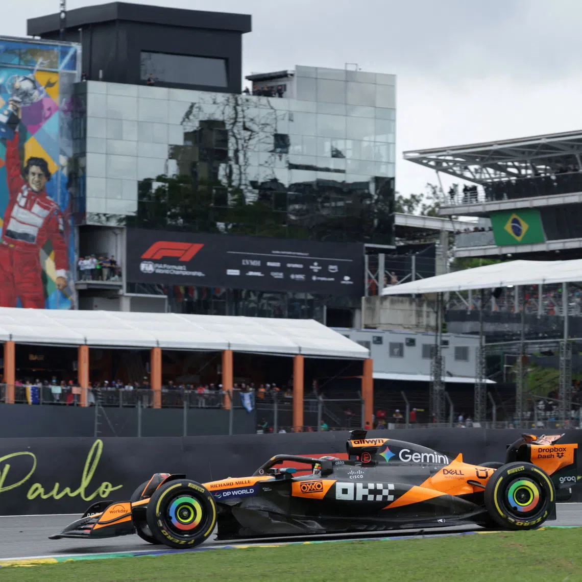 Formula One F1 - Sao Paulo Grand Prix - Autodromo Jose Carlos Pace, Sao Paulo, Brazil - November 9, 2025 McLaren's Oscar Piastri in action as a mural of former F1 driver Ayrton Senna is seen during the race REUTERS/Ricardo Moraes
