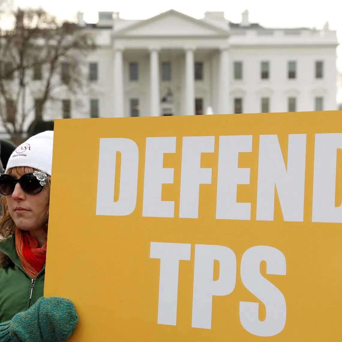 FILE PHOTO: Demonstrators hold signs advocating for Temporary Protected Status (TPS) in front of the White House in Washington, D.C., U.S., January 8, 2018. REUTERS/Kevin Lamarque/File Photo