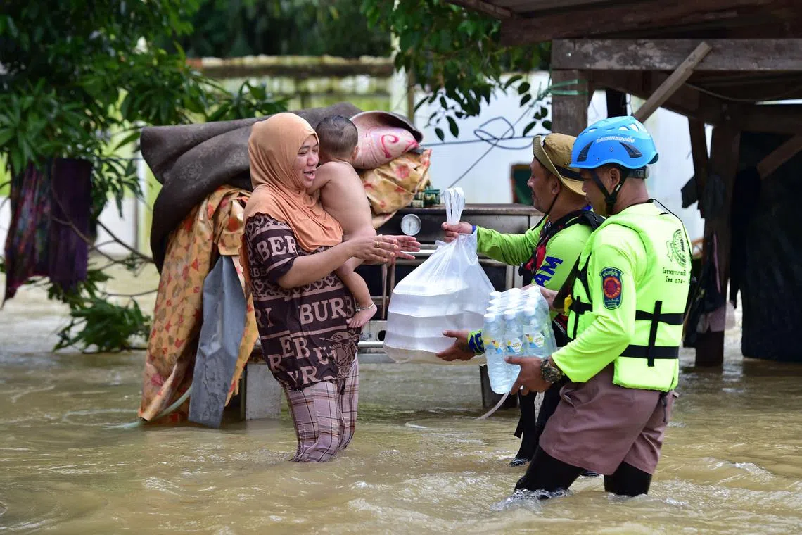 Disaster agency workers distribute food and drinking water in the southern Thai province of Narathiwat on Dec 21, 2022.