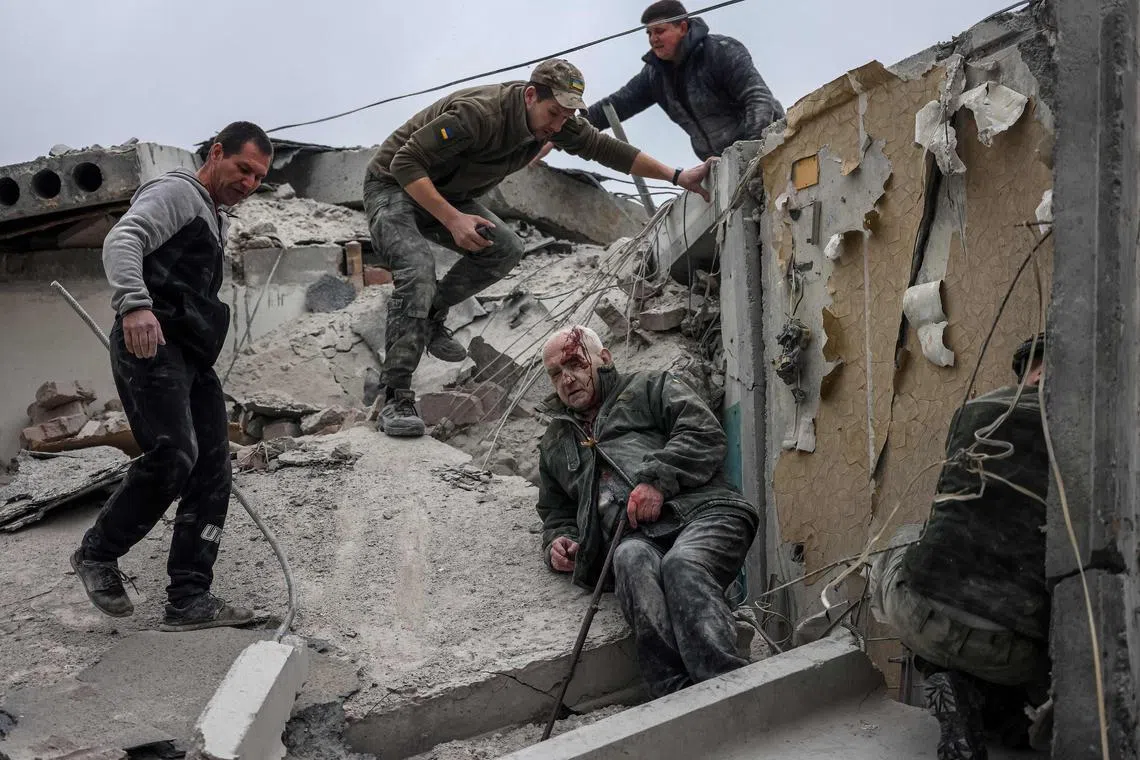Emergency workers rescue an injured elderly man from a partially destroyed residential building in Ukraine's Sloviansk.