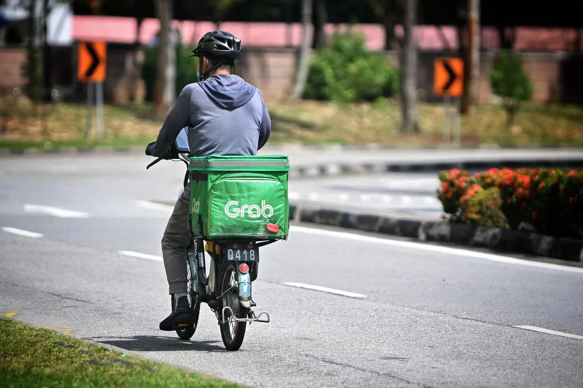Generic photo of a Grab Food delivery worker riding a bicycle at yishun ring road on January 9, 2023.
