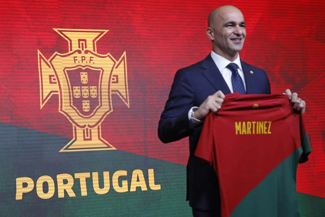 Portugal's new national team coach Roberto Martinez posing with a Portuguese national jersey with his name during his presentation at the Cidade do Futebol, in Oeiras, Lisbon, on Monday.
