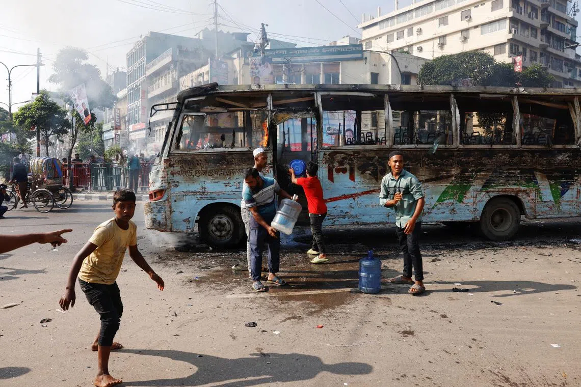 People try to douse the fire after unidentified miscreants set a public bus on fire during a countrywide strike from dawn to dusk called by the Bangladesh Nationalist Party (BNP), protesting against alleged police attacks on their Saturday rally in Dhaka, Bangladesh, October 29, 2023. REUTERS/Mohammad Ponir Hossain